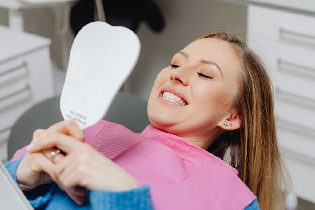 girl at the orthodontist looking in mirror at teeth